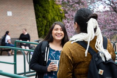 Two NAU indigenous studies students smile while chatting after class.