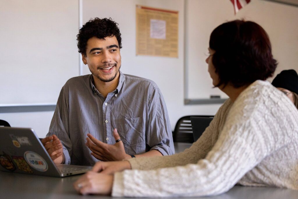NAU student, Isaiah Raspet, smiles while chatting with his professor.