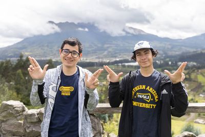 An NAU Honors College students smile while doing the Lumberjacks hand symbol while in Ecuador.