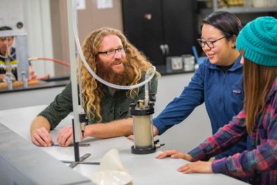 Students work with civil engineering equipment in a lab setting.